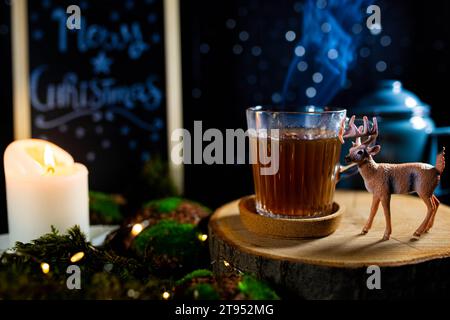 https://l450v.alamy.com/450v/2t952mg/christmas-still-life-with-hot-tea-cup-blackboard-and-deer-figurine-in-candle-lit-setting-2t952mg.jpg
