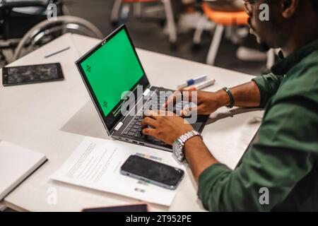 Businessman typing on laptop, green screen Stock Photo
