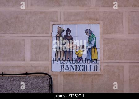 Traditional medieval tiled street sign "Pasadizo del Panecillo" (translation: The Bread Passage) embedded in the brick building facade in Madrid,Spain Stock Photo