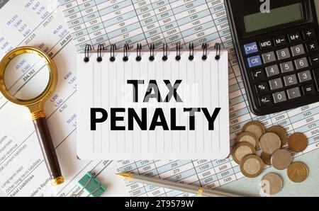 Text TAX PENALTY on white paper sheet and marker on businessman hand on the diagram. Business concept Stock Photo