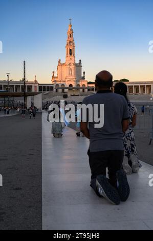 People walking the Penitential Path on knees towards the Chapel of the Apparitions. Sanctuary of Our Lady of the Rosary of Fátima in Fátima, Portugal. Stock Photo