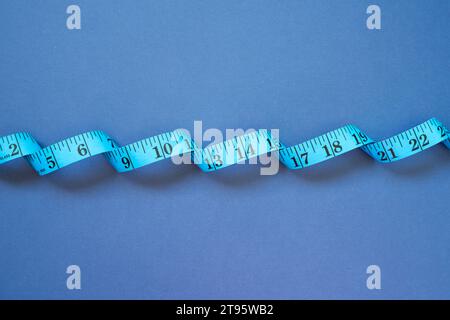 Tape measure on navy blue background. top view Stock Photo