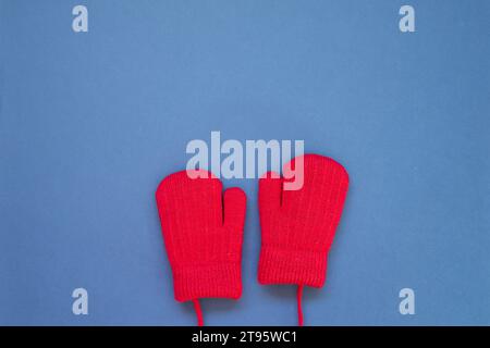 Winter knitted fur wool red gloves on navy blue background. top view, copy space Stock Photo