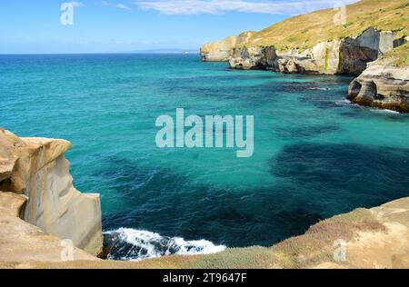 the picturesque, eroded coastline of tunnel beach on a sunny summer day, near dunedin, on the south island of new zealand Stock Photo