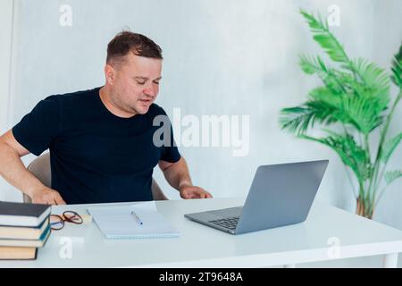 Man working on laptop in office cabinet Stock Photo