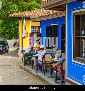 Koprivshtitsa, Bulgaria - September 24, 2023: Street scene with cafe, shops, locals, and visitors, in Koprivshtitsa, Bulgaria Stock Photo