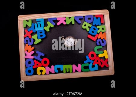 Pocket watch and colorful Letters of Alphabet made of wood Stock Photo