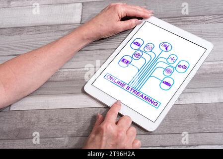 Online streaming concept shown on a tablet used by a woman Stock Photo