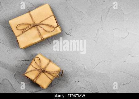 Presents on dark gray textured table background. Brown gift boxes decorated with crafter paper Stock Photo