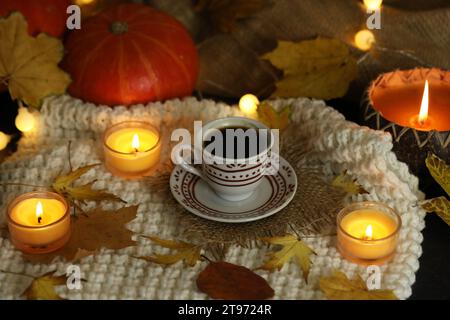 cup of coffee on the autumn background with leaves and candles Stock Photo