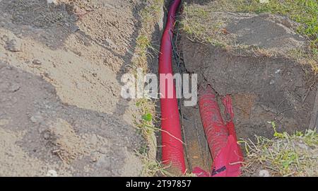 Cables in the trench. High-voltage cables in a protective covering in an excavation. Concept of electrical installations, construction works, building Stock Photo