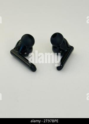 A close-up image of two black headsets, one of which is a pair of Bluetooth headphones Stock Photo