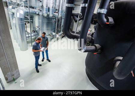 Two employees using laptop in factory Stock Photo