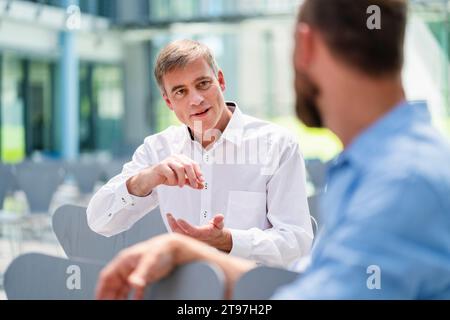 Two businessmen meeting in company auditory discussing business solutions Stock Photo