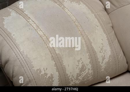 Defects on a white leather sofa. Damaged to leather furniture. Stock Photo