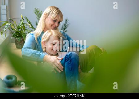 Smiling mother and son using tablet PC at home Stock Photo