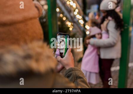 Boy photographing mother and sister through smart phone Stock Photo