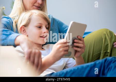 Mother with son using tablet PC at home Stock Photo