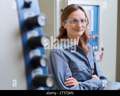 Smiling young woman with arms crossed at workshop Stock Photo