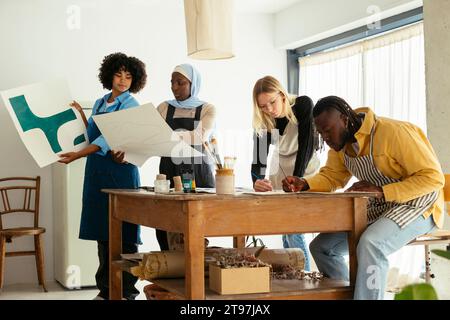 Artists working with paintings in studio Stock Photo