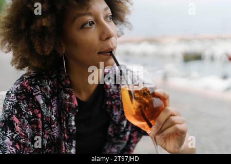 Thoughtful young woman drinking at bar Stock Photo