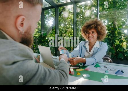 Smiling designers having discussion over color swatch in office Stock Photo