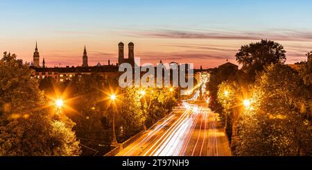Germany, Bavaria, Munich, Vehicle light trails along illuminated city road at dusk Stock Photo