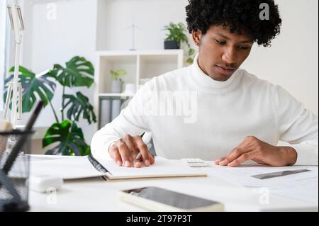 Focused businessman working at desk with documents in home office Stock Photo