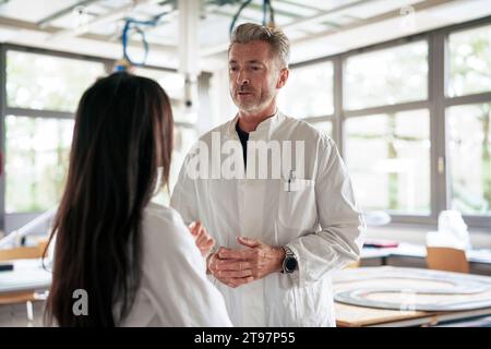 Scientists having discussion together in laboratory Stock Photo