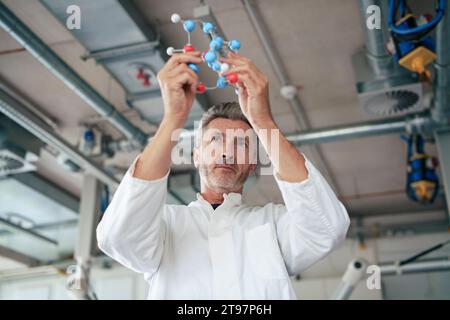 Mature scientist examining molecular structure Stock Photo