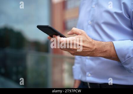 Businessman using mobile phone on balcony Stock Photo