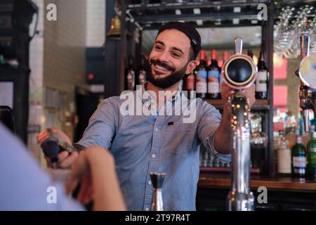 Smiling owner taking order from customer at pub Stock Photo