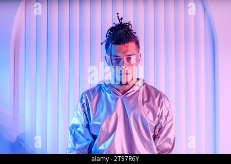 Man with box braids wearing smart glasses in front of wall Stock Photo