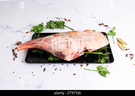 Raw lamb shoulder ready for cooking with garlic, rosemary. Black background. Top view Stock Photo