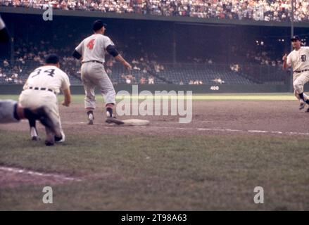 DETROIT, MI - JULY 4:  Third base coach Billy Hitchcock #34 of the Detroit Tigers indicates to Charlie Maxwell #4 to slide as thrid baseman George Strickland #4 of the Cleveland Indians waits for the throw during an MLB game on July 4, 1959 at Briggs Stadium in Detroit, Michigan.  (Photo by Hy Peskin) *** Local Caption *** Charlie Maxwell;Billy Hitchcock;Geroge Strickland Stock Photo