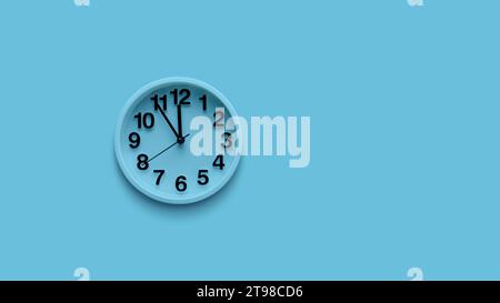 Blue clock on pastel blue background. Minimal time concept. Christmas or New Year minimal concept. Stock Photo