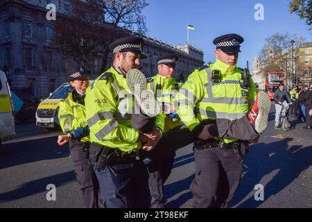 London, UK. 23rd Nov, 2023. Metropolitan Police officers arrest a Just Stop Oil activist during the demonstration in Whitehall outside Downing Street. The climate action group marched from Trafalgar Square on the pavement and were arrested within seconds of stepping on the road on the fourth day in a row as they continue their protests against new fossil fuel licences. Credit: SOPA Images Limited/Alamy Live News Stock Photo
