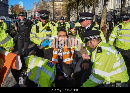 London, UK. 23rd Nov, 2023. Metropolitan Police officers arrest a Just Stop Oil activist during the demonstration in Whitehall outside Downing Street. The climate action group marched from Trafalgar Square on the pavement and were arrested within seconds of stepping on the road on the fourth day in a row as they continue their protests against new fossil fuel licences. (Photo by Vuk Valcic/SOPA Images/Sipa USA) Credit: Sipa USA/Alamy Live News Stock Photo