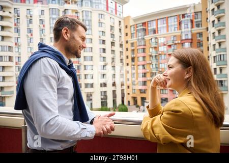 Managers, female and male communicate on large balcony of office building Stock Photo