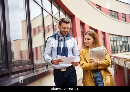 Colleagues review work documents on the terrace of office building Stock Photo