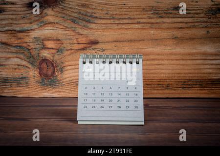 JUNE 2024 cardboard desk calendar on a wooden texture background. Stock Photo