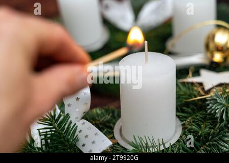 Augsburg, Bavaria, Germany - November 23, 2023: First Advent, A hand holds a burning match and lights the candle on the 1st Sunday of Advent *** Erster Advent, Eine Hand hält ein brennendes Streichholz und zündet die Kerze am 1. Adventssonntag an Credit: Imago/Alamy Live News Stock Photo