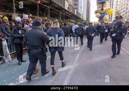 New York, United States. 23rd Nov, 2023. Protesters under arrest are led away by NYPD police officers and the Macy's Thanksgiving Day Parade resumes after a handful of pro-Palestinian protesters jumped the barricades and ran into the street along the parade route on Sixth Avenue in New York City. Credit: SOPA Images Limited/Alamy Live News Stock Photo