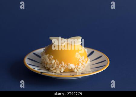 Close Up Mango Mousse Dome Served On Plate, Isolated On Blue Background Stock Photo