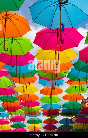 Multicolored umbrellas against a blue sky Stock Photo