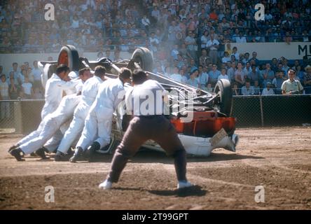 SACRAMENTO, CA - AUGUST, 1958: A group of men run to help the driver after crashing during a car show at the Sacramento State Fair circa August, 1958 in Sacramento, California. (Photo by Hy Peskin) Stock Photo