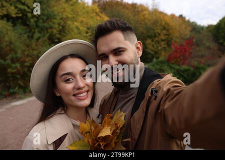 Happy young couple taking selfie in autumn park Stock Photo