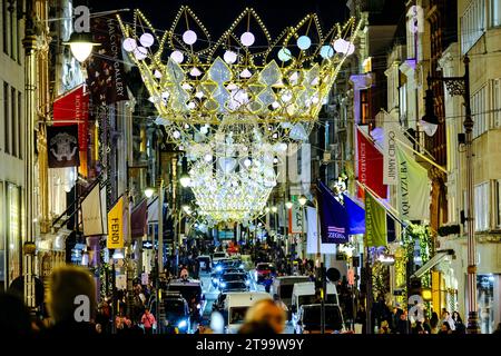 London, UK. 23rd November, 2023. Visitors and shoppers admire the Christmas shop displays in New Bond Street and Old Bond Street, which also features festive lights inspired by the Crown Jewels. Credit: Eleventh Hour Photography/Alamy Live News Stock Photo