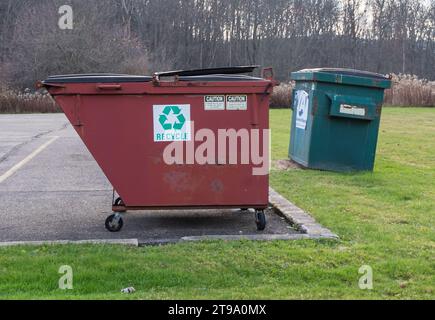 Two garbage dumpsters next to each other with one in a parking lot in Warren, Pennsylvania, USA Stock Photo