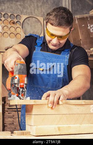 A carpenter using a jigsaw to cut wood cuts bars. Stock Photo